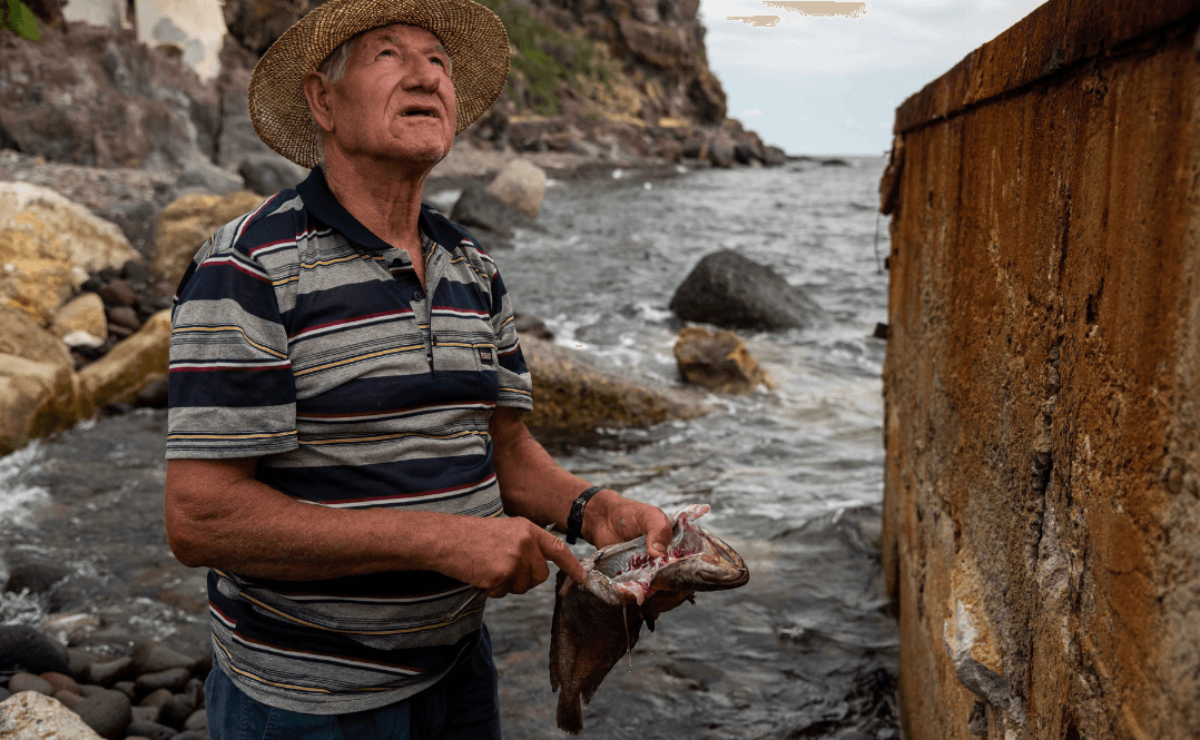 Rybak demonstrujący uśmiercanie ryb turystom.