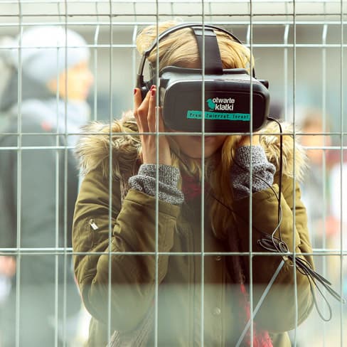 Osoba, która poznaje realia przemysłowego chowu zwierząt za pomocą gogli VR